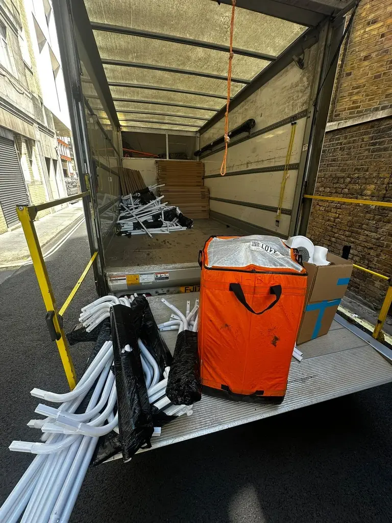 Crate and display stands on the tail lift of a 2FAST van in a London service yard