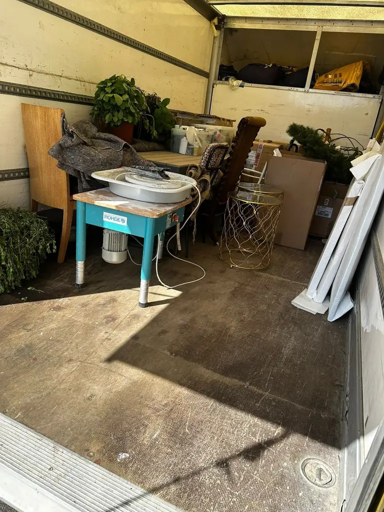 House plants, a side table and furniture loaded into the back of a 2FAST removals van